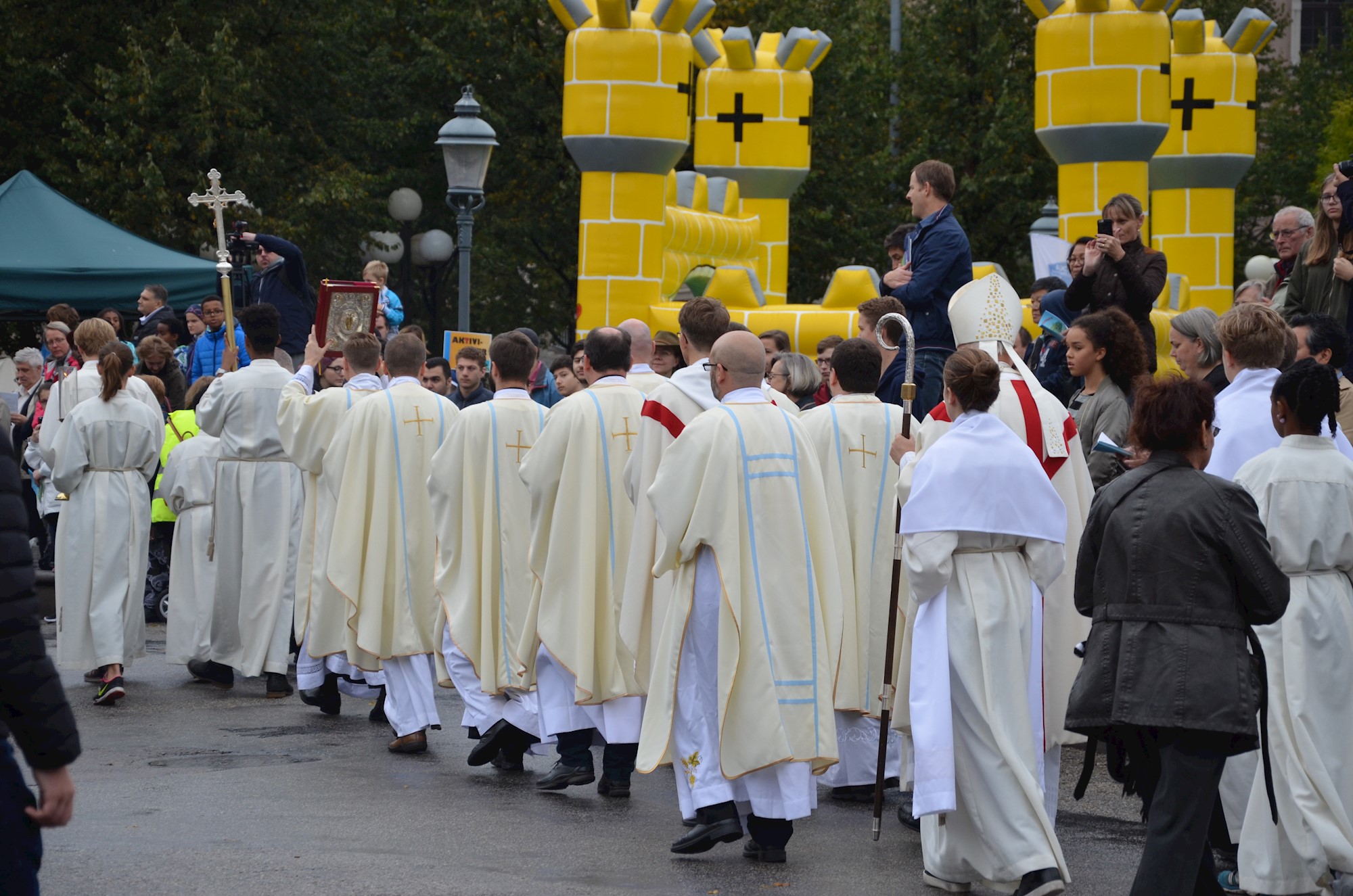 Kardinalen, präster, diakoner och ministranter gick procession genom parken.